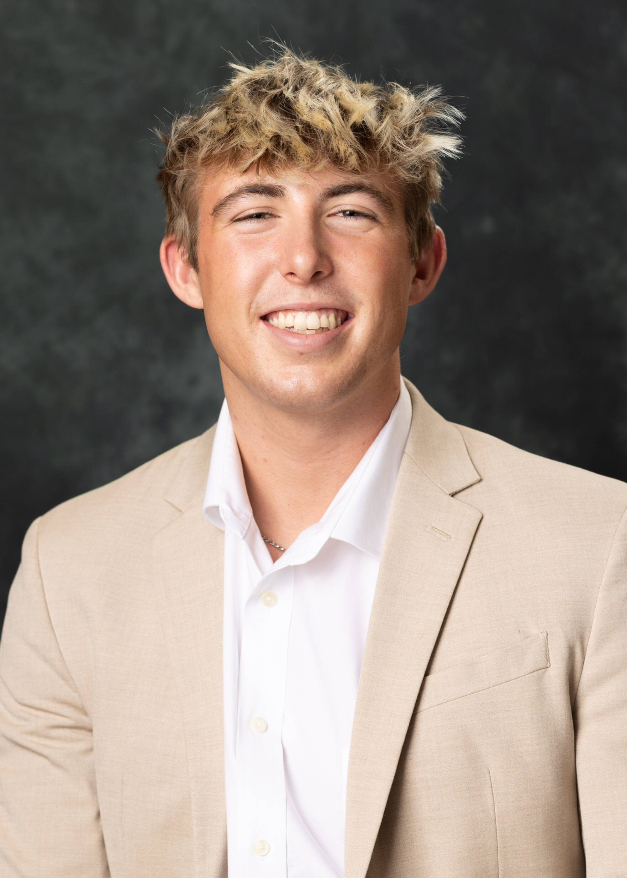 Tyler Fedototszkin smiling in a cream-colored suit